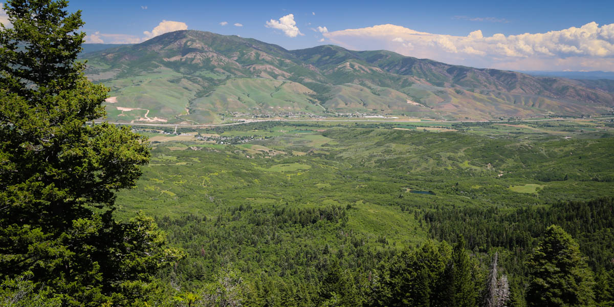 Scenic valley view of Utah mountains and open green land